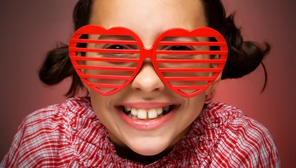 Menina sorridente com persianas — Fotografia de Stock