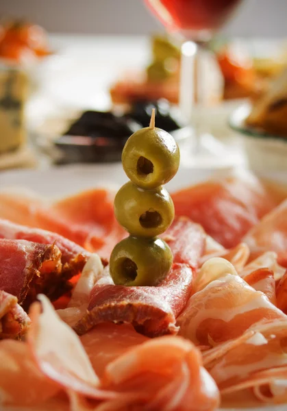 Prosciutto with green olives — Stock Photo, Image