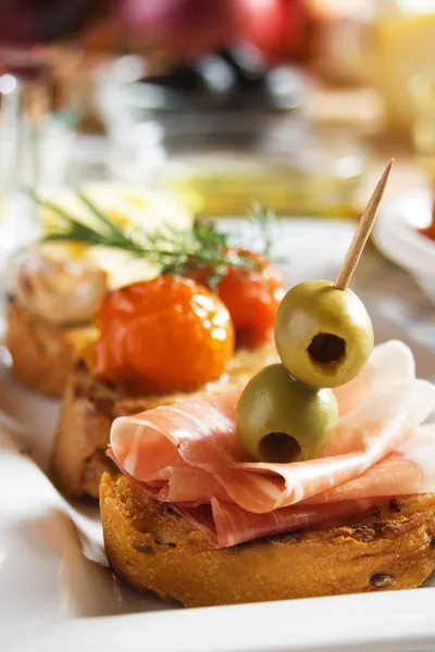 Bruschetta with prosciutto and olives — Stock Photo, Image
