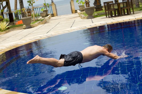 Homem tenta pular na água na piscina — Fotografia de Stock