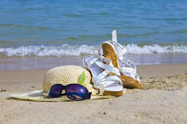 Solglasögon, stråhatt och sandal låg på — Stockfoto