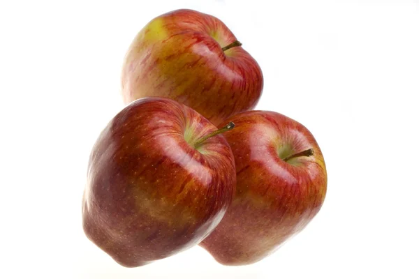 Три сочных яблока лежали на белой заднице — стоковое фото