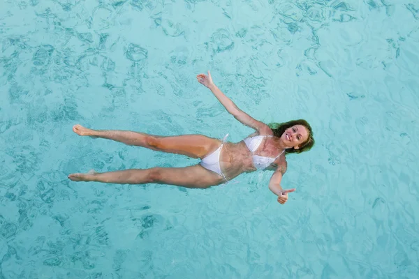 Młoda kobieta uśmiecha się, pływając w oceanie — Zdjęcie stockowe