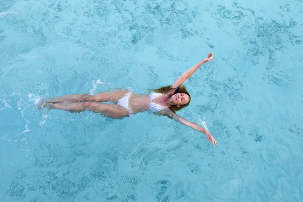 젊은 여자가 웃으며 바다에서 수영 한다 — 스톡 사진