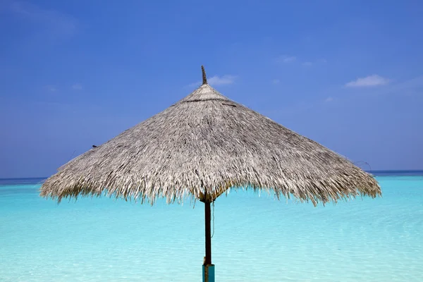 Sonnenschirm und Meer im Hintergrund — Stockfoto