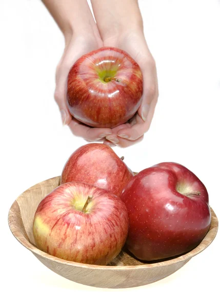 Mãos esticar maçã e tigela com maçãs — Fotografia de Stock