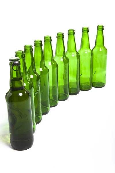 Порожні скляні пляшки і один повний — стокове фото