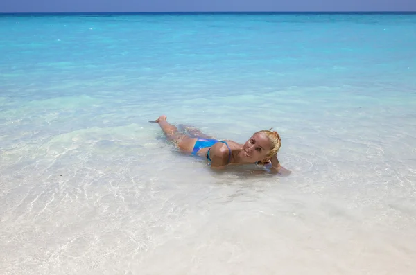 Sunburnt young blonde lays in ocean — Stock Photo, Image