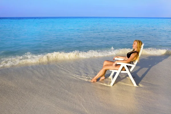 Mulher bronzeados em cadeira de praia no oceano — Fotografia de Stock