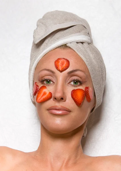 Женщина с косметической упаковкой из клубники — стоковое фото