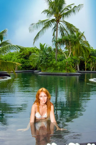 年轻漂亮的游泳池在热带花园中的女人 — 图库照片