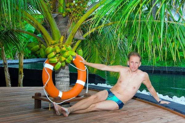 Man onder palmboom bij zwembad. Maldiven. — Stockfoto