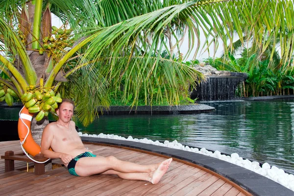 Człowiek pod palmą na basen. Malediwy. — Zdjęcie stockowe
