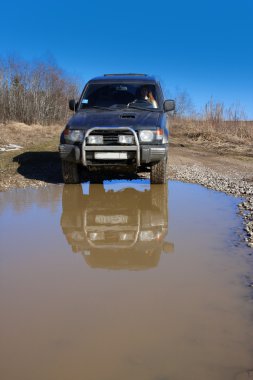 su engel önce toprak yolda offroad araba dümenini arkasında genç kadın