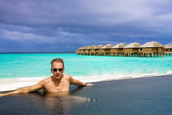 Homem na piscina e oceano ao fundo. Maldivas — Fotografia de Stock