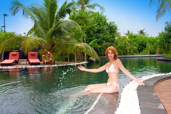 Unga vackra kvinnan i pool i tropisk trädgård — Stockfoto