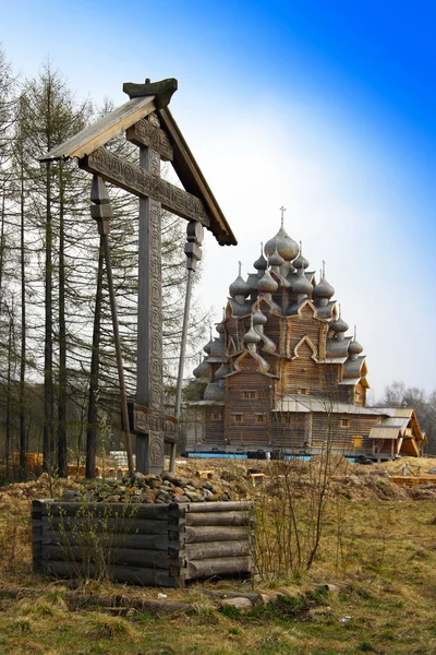 Cross before Wooden orthodox church in name of Cover All-holy mother of God — Stock Photo, Image