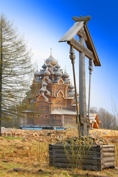Cross before Wooden orthodox church in name of Cover All-holy mother of God — Stock Photo, Image