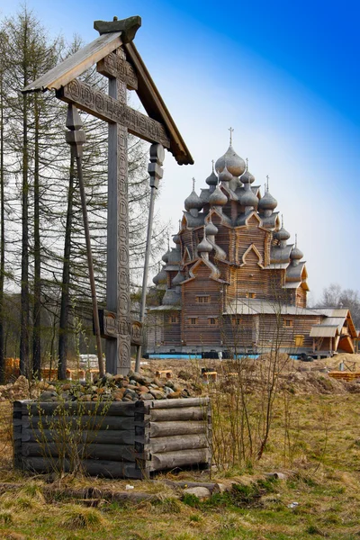 Kříž před dřevěný pravoslavné církve v jméno krytí all Svaté matky Boží — Stock fotografie