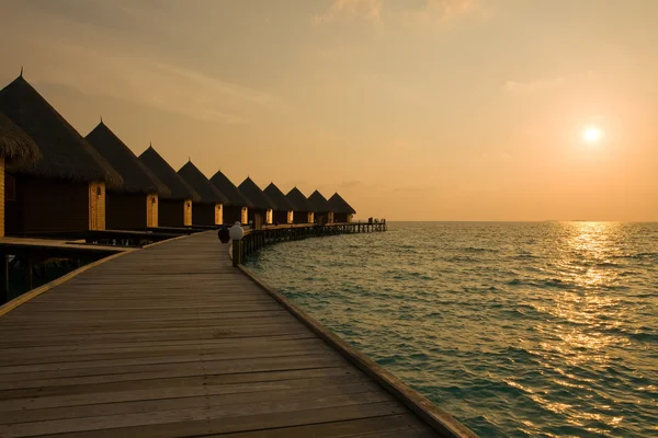 Malediven. Villa auf Pfählen am Wasser zum Zeitpunkt des Sonnenuntergangs. — Stockfoto