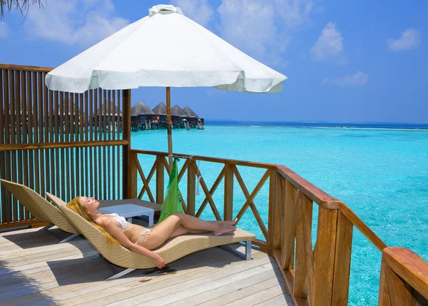 Jonge mooie vrouw op platform in villa op water, Maldiven — Stockfoto