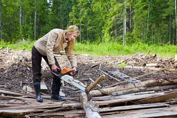 Frau in Holz sägt Baum mit Kettensäge — Stockfoto