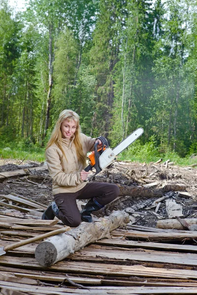 Mulher em serras de madeira uma árvore uma serra de corrente — Fotografia de Stock