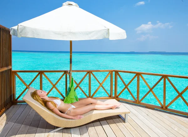 Ung kvinna solbränna på villa på havet Maldiverna — Stockfoto