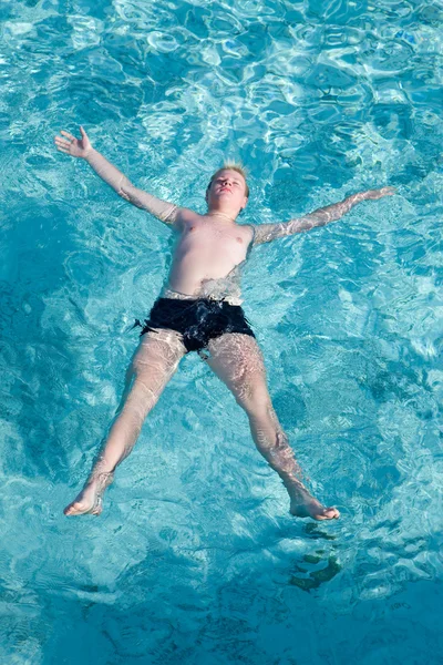 Pojken har en vila på öppet vatten i havet — Stockfoto