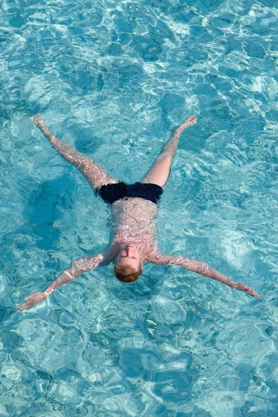 Der Junge erholt sich auf dem transparenten Wasser des Ozeans — Stockfoto