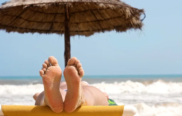 Vrouw voeten op het strand — Stockfoto