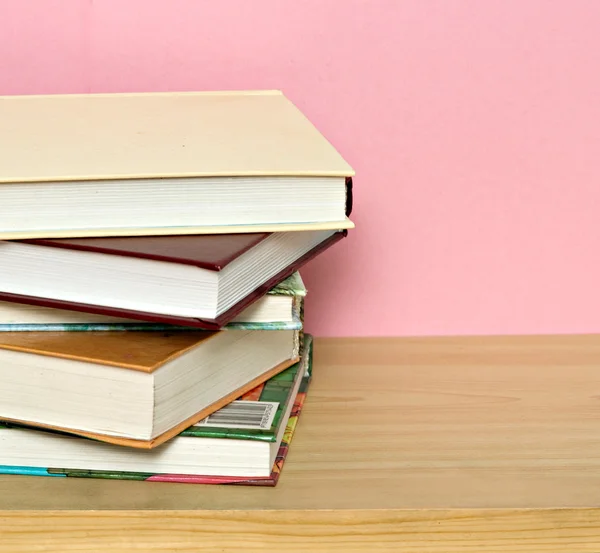 Pile of colorful books isolated on pink backgrou — Stock Photo, Image