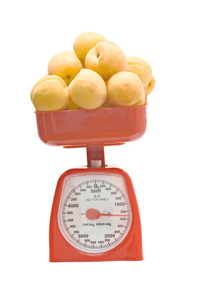 stock image Red kitchen scale weighting apricots