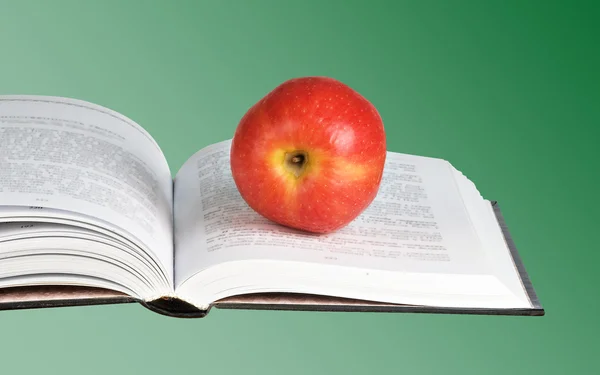 Pomme rouge sur livre ouvert — Photo