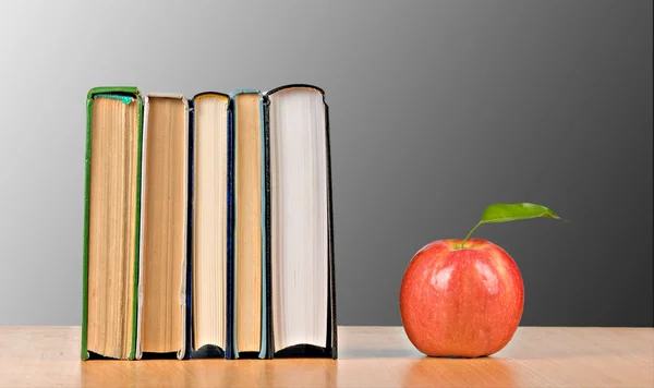 Красное яблоко и книги — стоковое фото