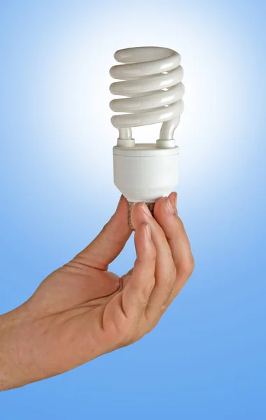 El tutarak bir enerji tasarrufu lambası — Stok fotoğraf