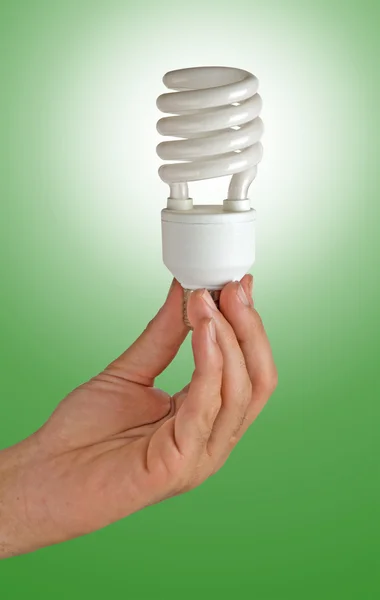 Main tenant une lampe à économie d'énergie — Photo
