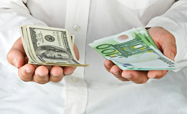 Homem com euro e dólares — Fotografia de Stock