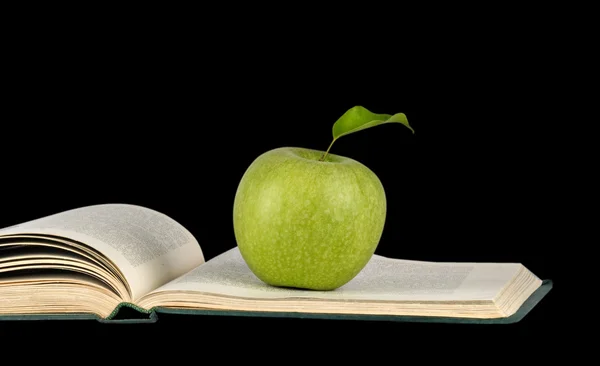 Manzana en libro aislado sobre fondo negro —  Fotos de Stock