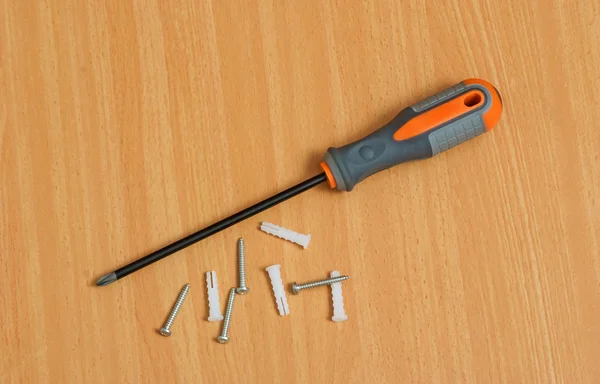 Screwdriver and screws on desk — Stock Photo, Image