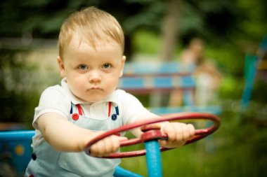 Boy playing with a wheel on playgroung clipart