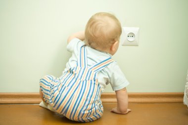 Child near the socket clipart