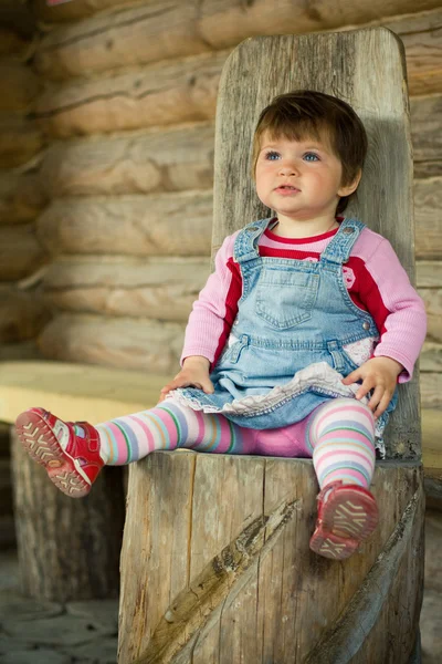 Девушка на деревянном стуле — стоковое фото