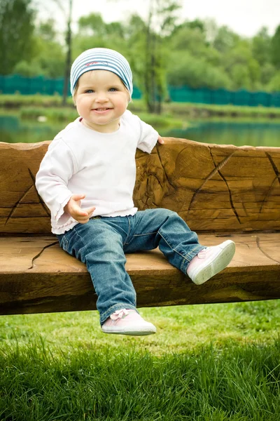 Fille sur un banc en bois — Photo