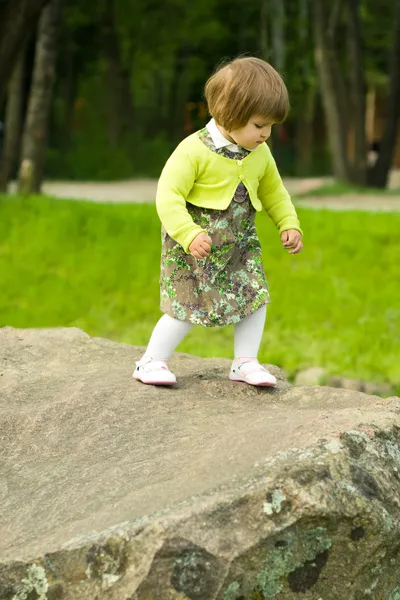 Девушка на камне в парке — стоковое фото