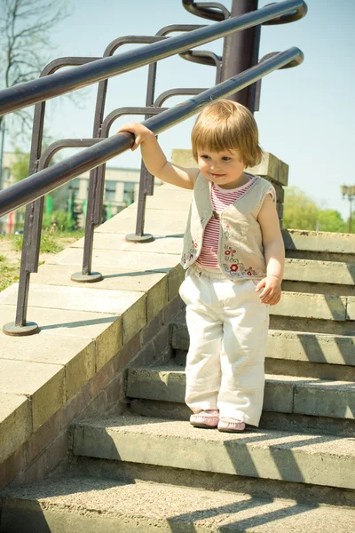 Mała piękna dziewczynka na schodach. — Zdjęcie stockowe