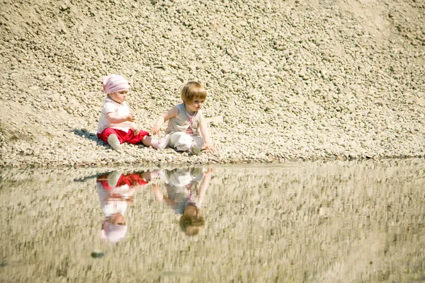 Bambine sedute su una spiaggia di sassi — Foto Stock