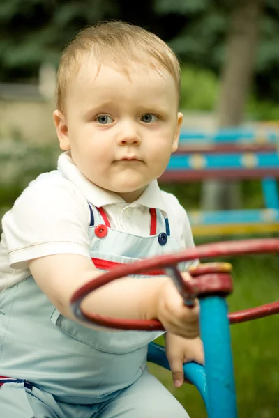Jongen speelt met een wiel op playgroung — Stockfoto