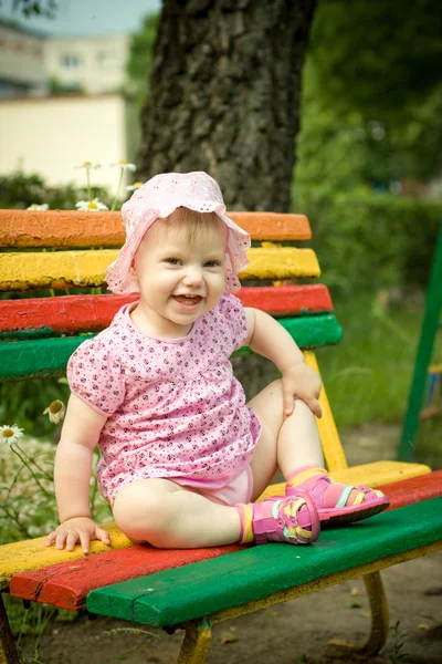 Little girl on the bench in park — Stock Photo, Image