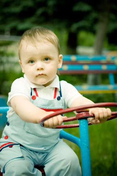 Menino brincando com uma roda em playgroung — Fotografia de Stock